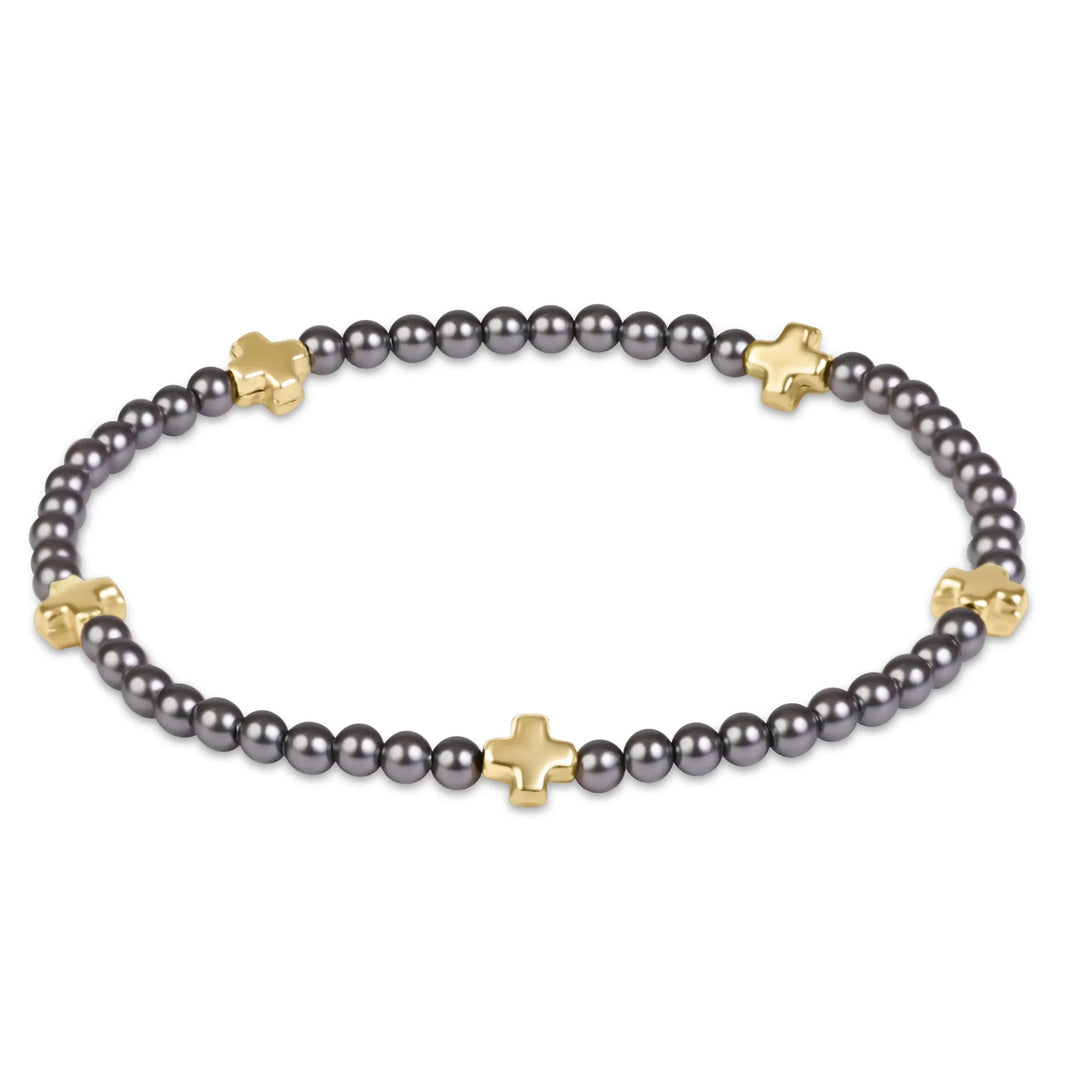 Enewton Signature Cross bracelet with dark grey pearl crystals and small gold-filled crosses on a white background
